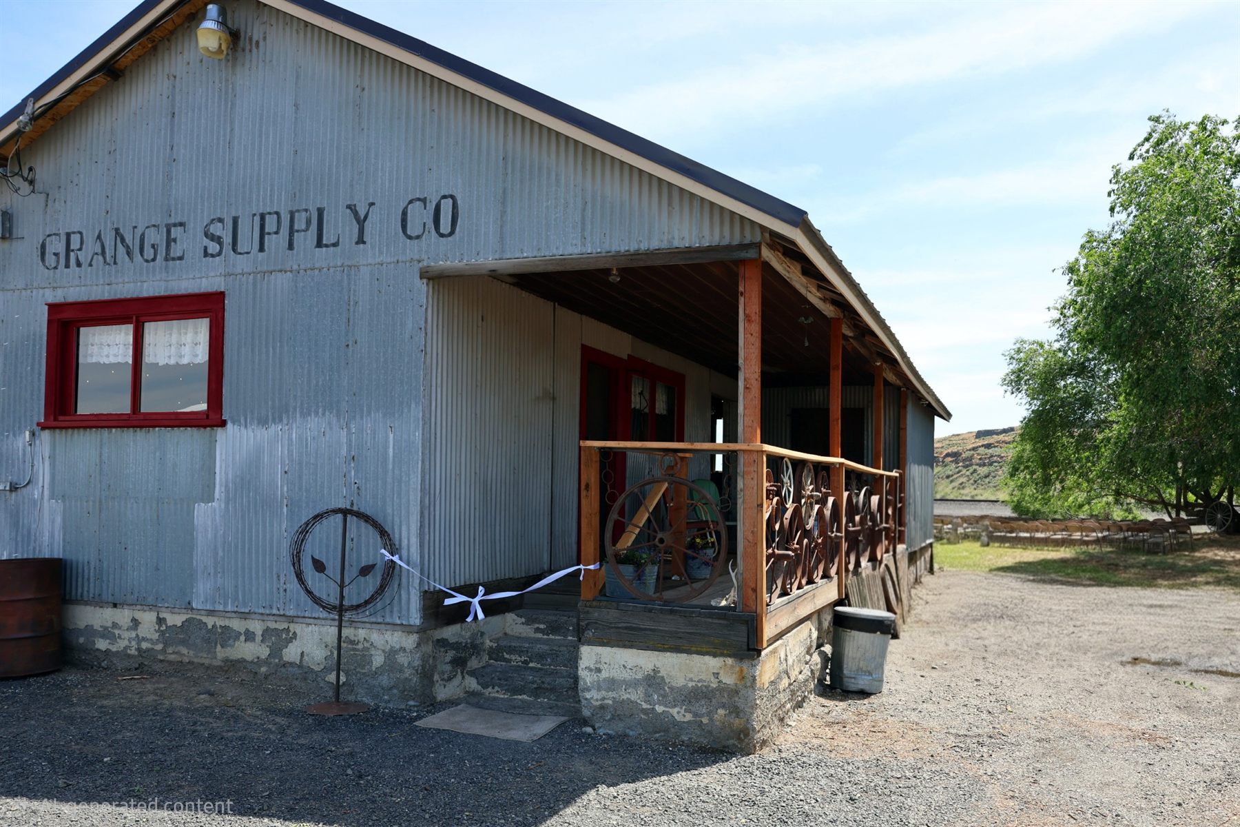 The restored Grange Supply Co building with porch, red trim, and outdoor gathering space.